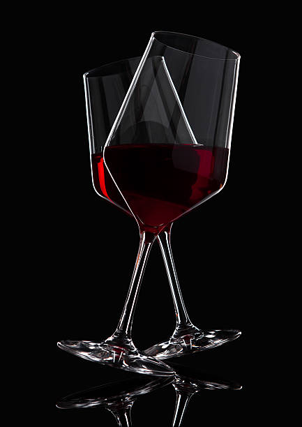 istock Glasses of red wine with reflection on black 628612440