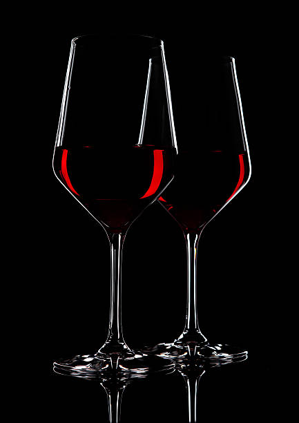 istock Glasses of red wine with reflection on black 628612562