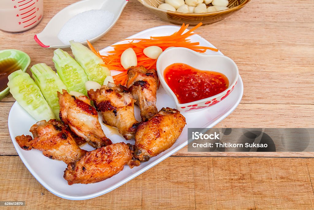 Fried chicken with fish sauce Fried chicken with fish sauce on wood table. Animal Body Part Stock Photo