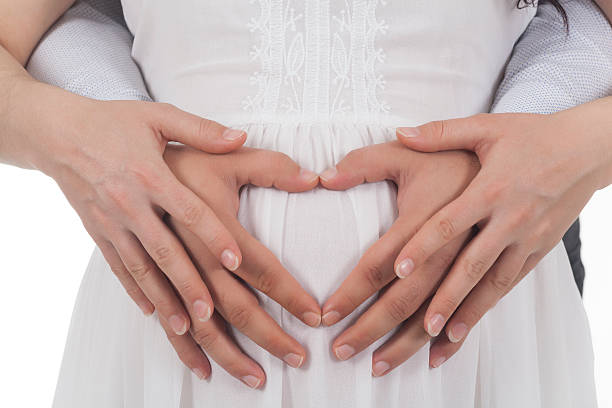 istock pregnant woman and husband doing heard shape with hands 628612998