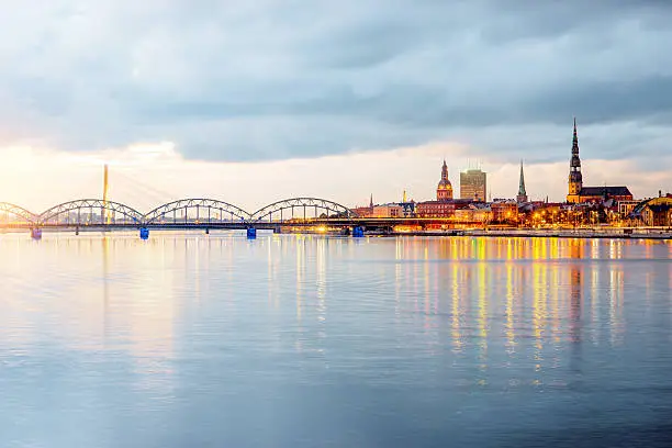 Night view on the illuminated riverside with reflection on the river in Riga, Latvia