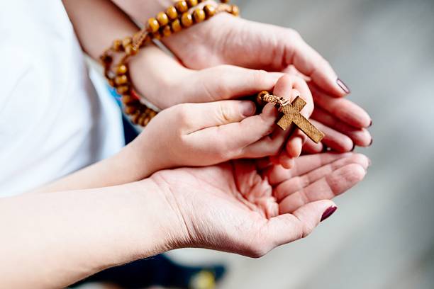 Family prayer with wooden rosary Family prayer. Mother and child hands with wooden rosary praying child christianity family stock pictures, royalty-free photos & images