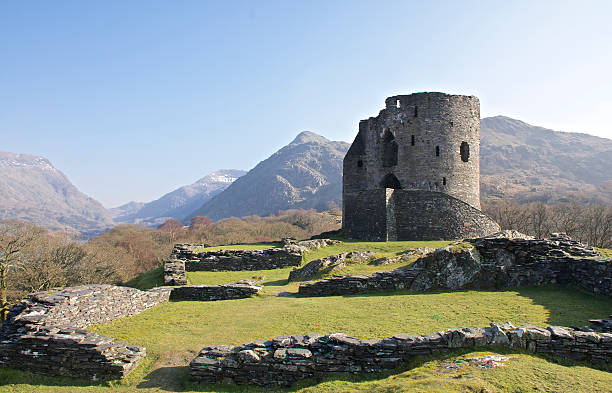 Dolbadarn Castle Keep in Llanberis, 13th century, near Padarn lake. Wide shot of Dolbadarn Castle Keep on a clear summers day showing the staircase and surrounding ruins overlooked by mountains and lush green grass. snowdonia stock pictures, royalty-free photos & images