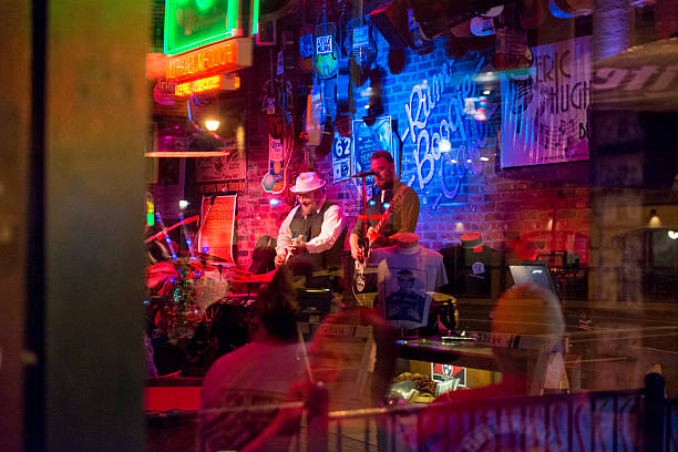Live Music Nightlife Entertainment Beale Street Memphis Tennessee Southern USA Memphis, United States - May 17, 2016: At night on Beale Street people can be seen through the window listening to live music being played. Buildings across the street are visible in the glass' reflection. memphis tennessee stock pictures, royalty-free photos & images
