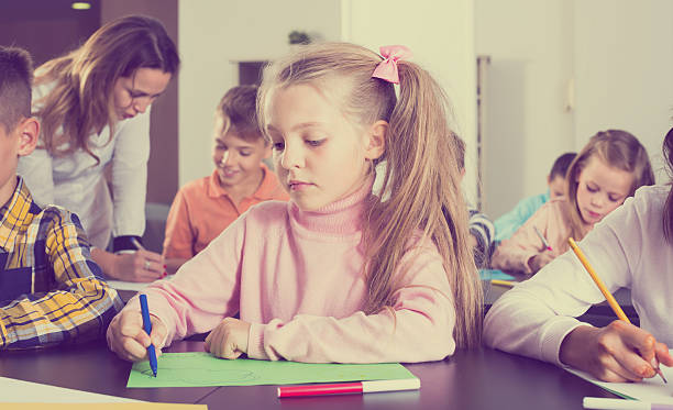 little children with positive teacher drawing in classroom - report card number 8 school education imagens e fotografias de stock