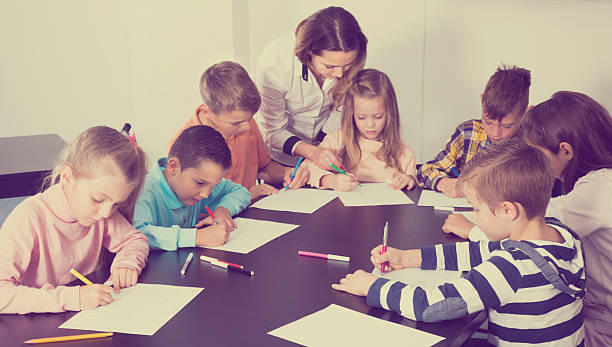 teacher and elementary age children drawing at classroom - report card number 8 school education imagens e fotografias de stock