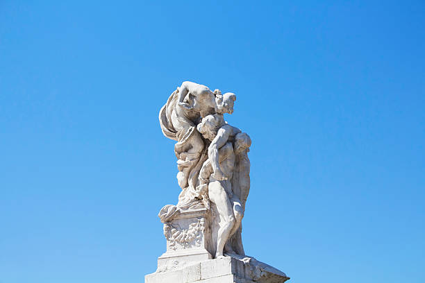 Woman kisses man statue in front of Altar of the Fatherland in Rome. Grand marble, classical temple honoring Italy's first king & First World War soldiers.