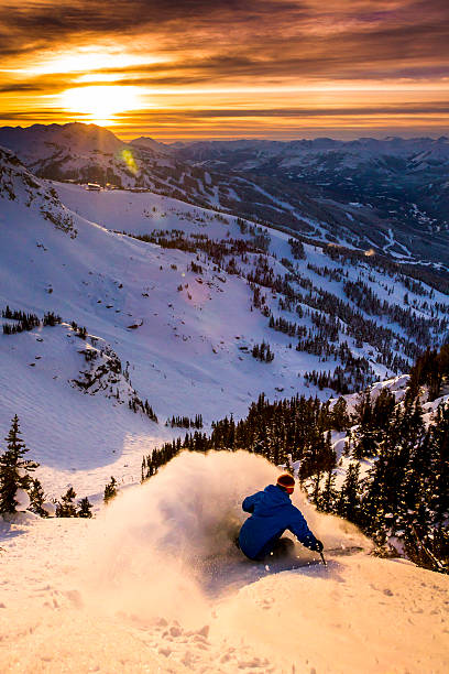atleta masculino esquiando em pó profundo durante o pôr do sol. - skiing winter sport powder snow athlete - fotografias e filmes do acervo