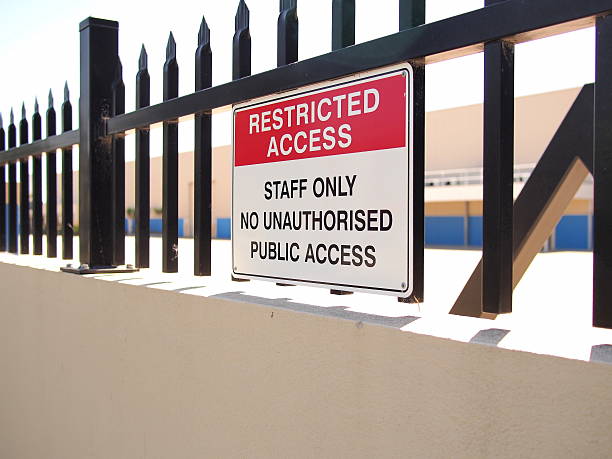 istock Access restricted sign on a steel fence tipped wall 628647678