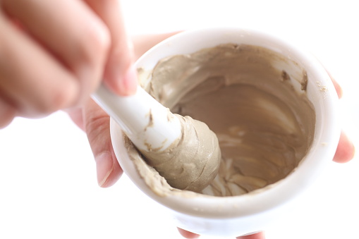 Up the hands of a woman mixing clay