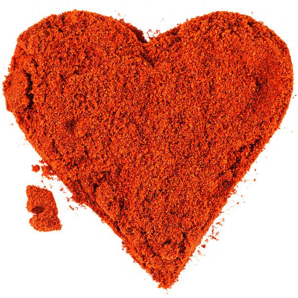 istock Red heart from powdered chili pepper isolated on white background 628651194