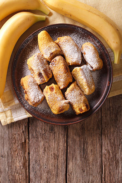 istock Fried bananas in batter on plate. Vertical top view 628658858