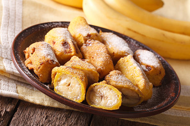 istock Tasty fried bananas in batter with powdered sugar. Horizontal 628659106