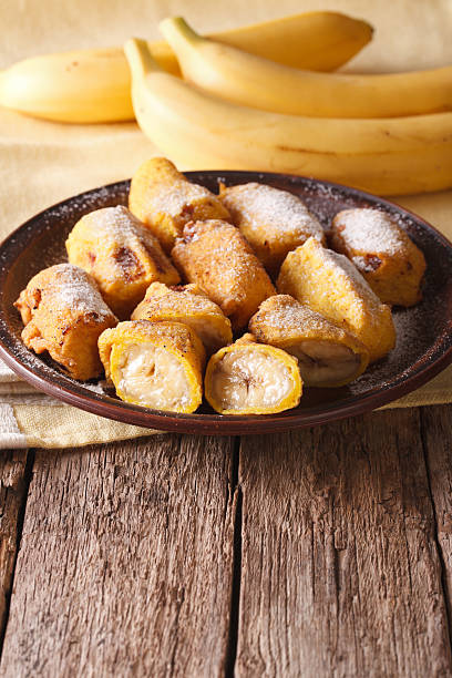 istock Tasty fried bananas in batter with powdered sugar. vertical 628659150