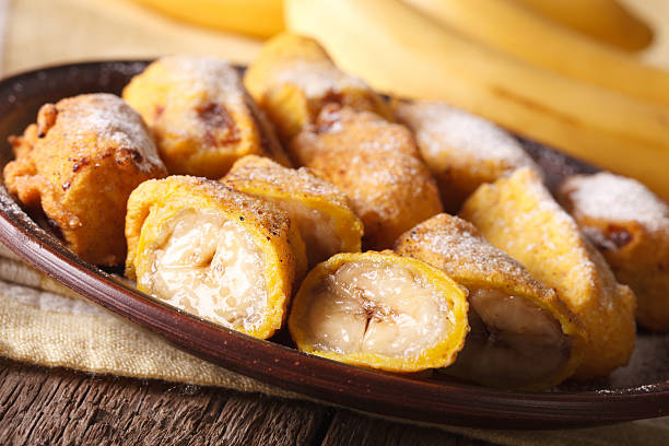 istock Fried bananas sprinkled with powdered sugar close-up. horizontal 628659214