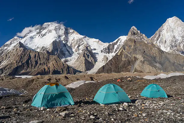 Blue tents at Concordia camp in front of Broadpeak mountain, K2 trek, Pakistan, travel Asia