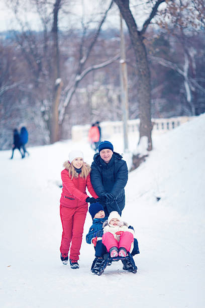 istock Young Family Running Through Snow With Sled 628663154