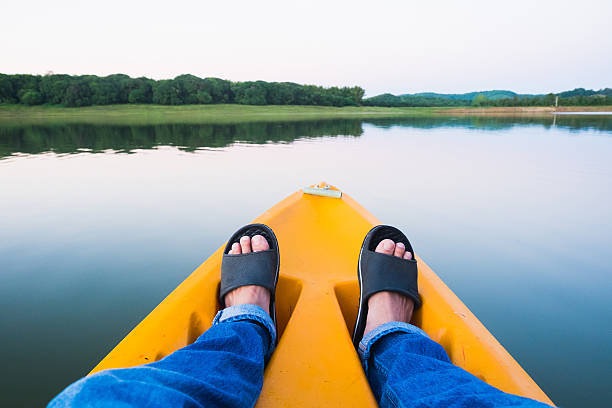 istock Feet relaxing on orange kayak floating on river and autumn 628663190