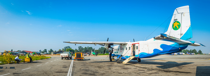 Kathmandu, Nepal - October 17, 2016: A Tara Air Dornier 228 STOL aircraft and ground crew waiting for passengers to Lukla on the domestic apron of  Tribhuvan International Airport in the heart of Kathmandu, Nepal's vibrant capital city. Composite panoramic image created from seven contemporaneous sequential photographs. 