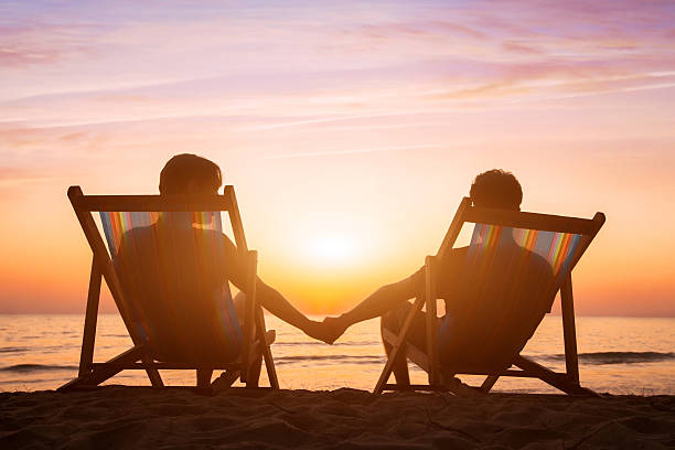 istock honeymoon, couple relaxing on the beach at sunset 628665082
