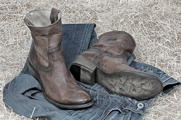 istock Leather cowboy boots and jeans on straw 628665272