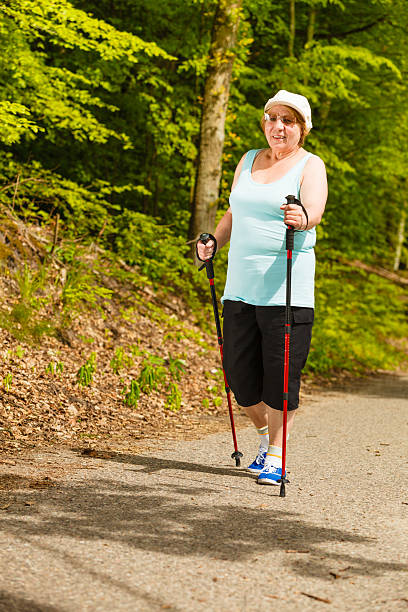 istock Senior woman practicing nordic walking in park 628665536