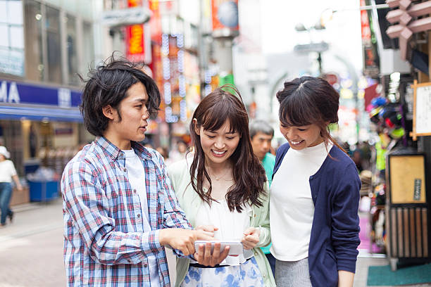 istock Young asian friends using smart phone on street 628665568