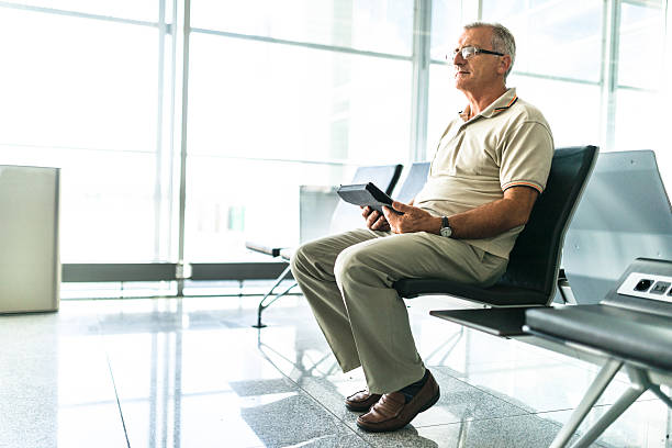 istock man reading a tablet on a contemporary airport lounge 628666006