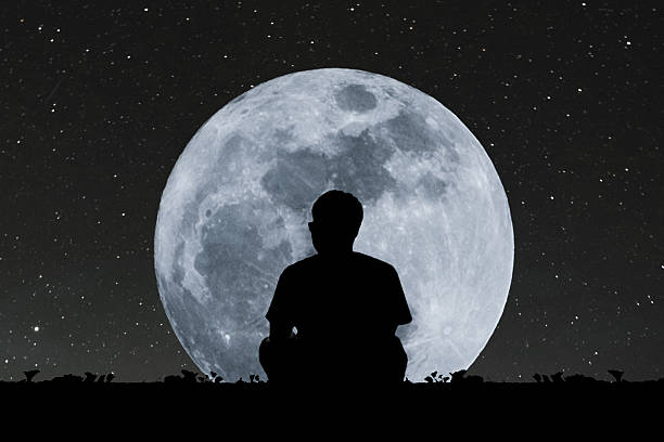 istock Silhouette a man sitting relaxing under full moon at night 628696180