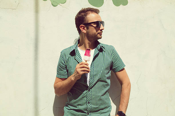 Hipster man eating ice cream outdoors. Summer concept.