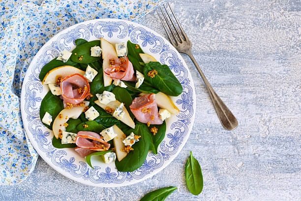 istock Salad with spinach, blue cheese, ham and pear sauce. 628709406