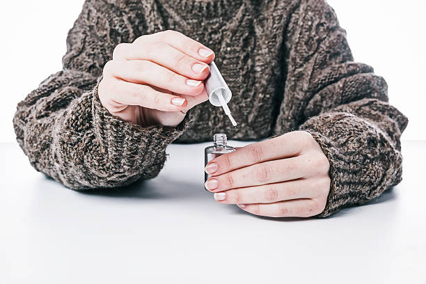 Hands holding nail coat Human hands holding nail coat directing to the viewer. Selective focus. Front view hardener stock pictures, royalty-free photos & images