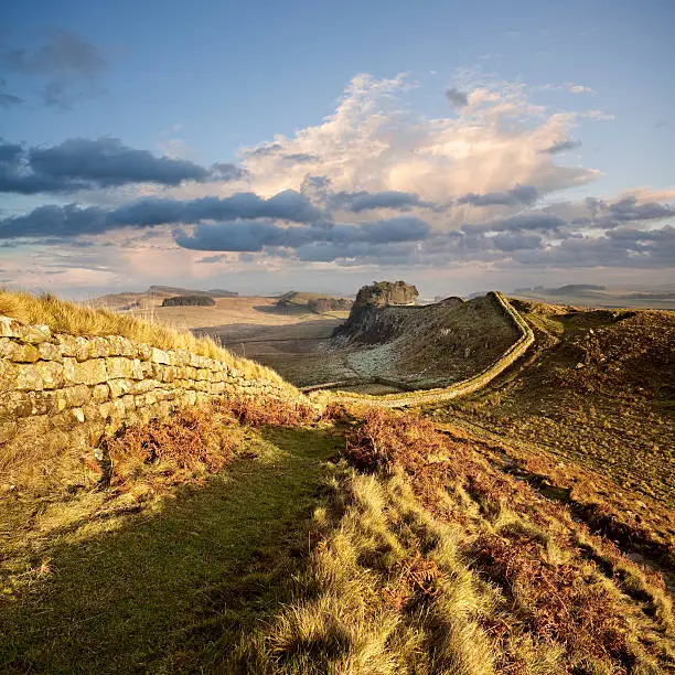 Hadrian’s Wall snakes its way across the landscape in Northumberland, England, illuminated by a pastel winter sunset