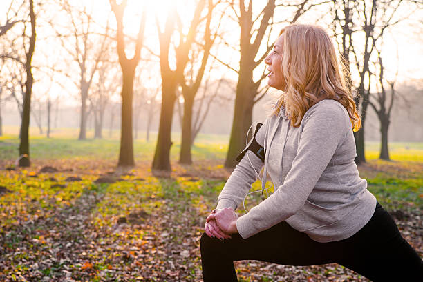 istock Mature woman exercising in park, stretching 628736518