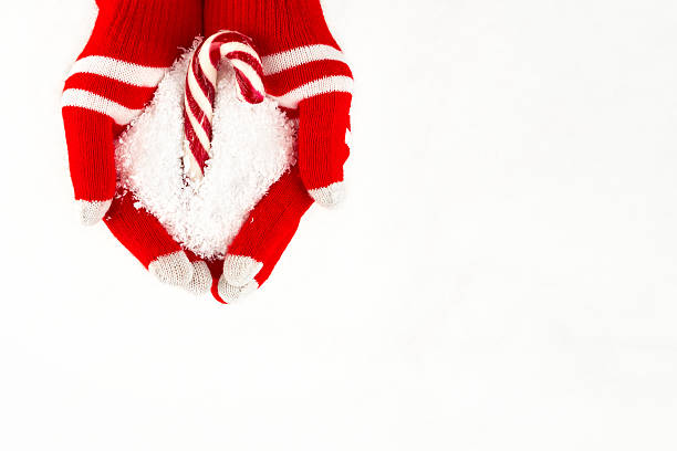 istock Christmas card, gloves on hands holding hook candy with snowflak 628746832