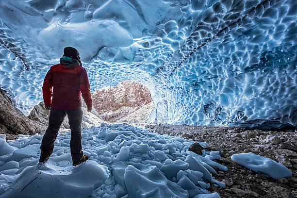 caminhante com cãibra olhando para fora da caverna de gelo - berchtesgaden - ice climbing - fotografias e filmes do acervo