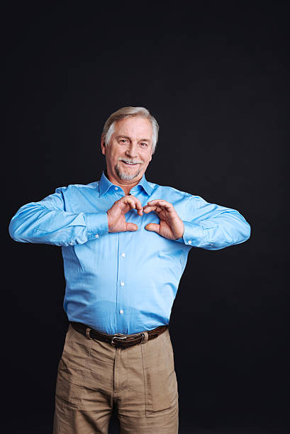 Old man holding hands in shape of heart