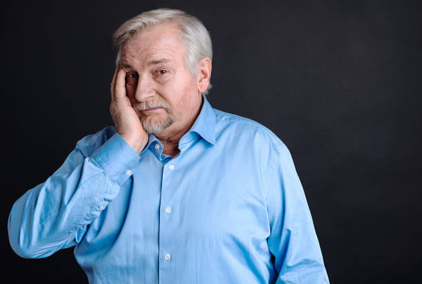 istock Worried old aged man covering his face with hand 628750420