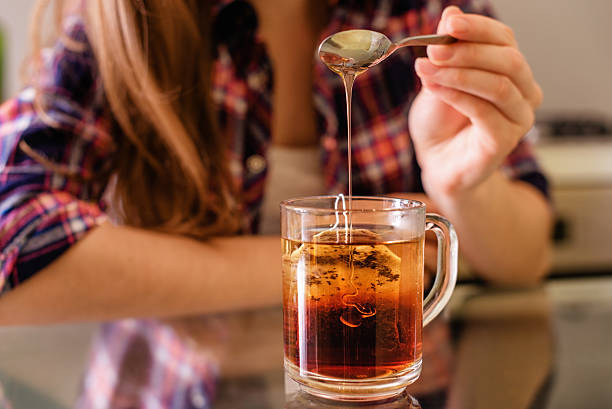 istock young woman add honey into tea 628751622