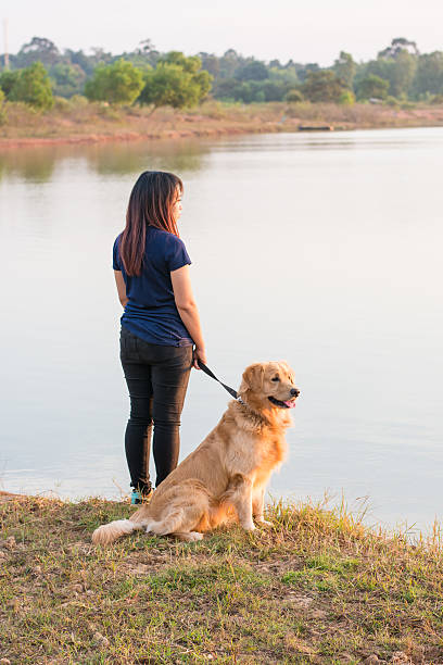 istock woman and golden dog on riverside 628753590