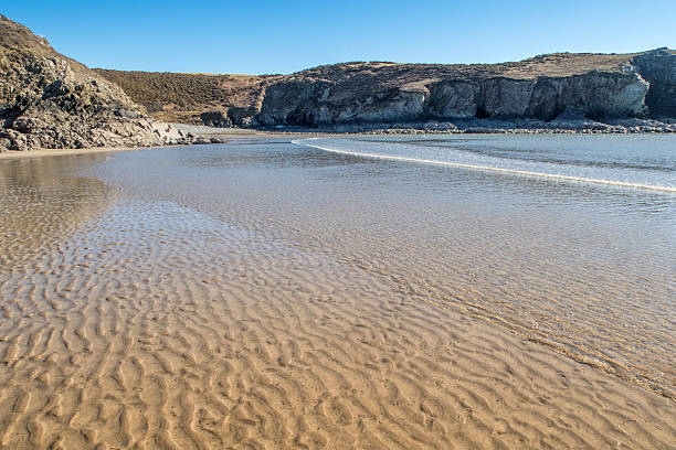 Looking across the sandy quiet beach at Solva, Pembrokeshire,  United Kingdom