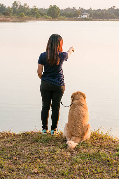 istock woman and golden dog on riverside 628754524