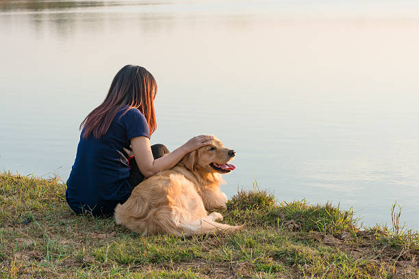 istock woman and golden dog on riverside 628760090