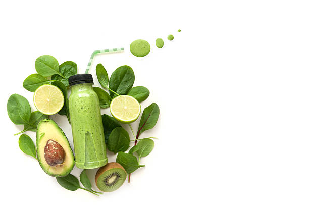 Green smoothie with space Bottled detox drink surrounded by green foods including spinach and kiwi detox stock pictures, royalty-free photos & images