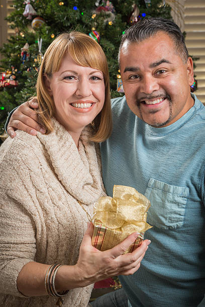 istock Young Mixed Race Couple with Present Near Christmas Tree 628763318