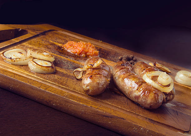 istock sausages a grill on a board with garlic and onions 628766424
