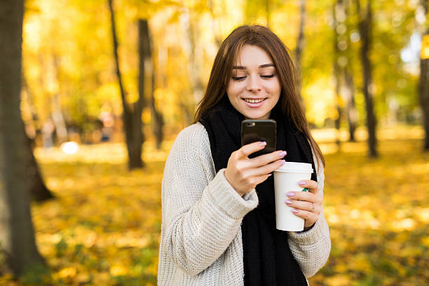 istock girl taking selfie on phone with coffee on yellow park 628767196