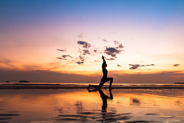 istock beautiful yoga pose on the beach at sunset 628767438