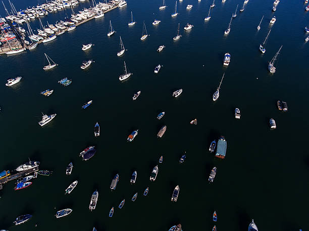 Aerial view of yachts and boat berthed in the marina and clear water
