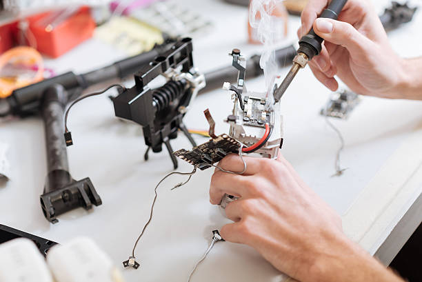 istock Detailed close up of mans hands soldering drone chips 628790816